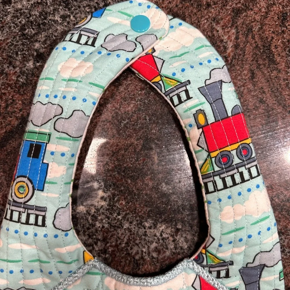 Handmade reversible quilted baby bib in train print